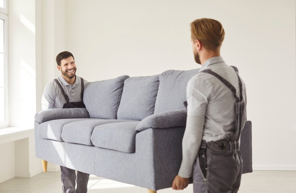 service,team,,two,men,carrying,large,sofa,,moving,furniture,,working